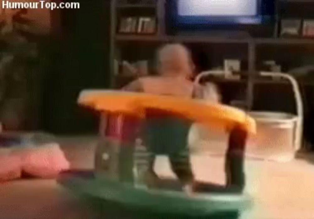 a baby is sitting in a walker with humourtop.com written in the corner