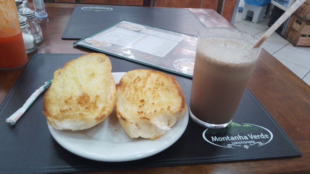 Foto de pão na chapa com copo de chocolate batido no gelo