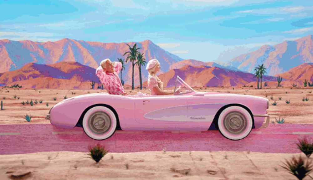 a man and a woman are driving a pink corvette