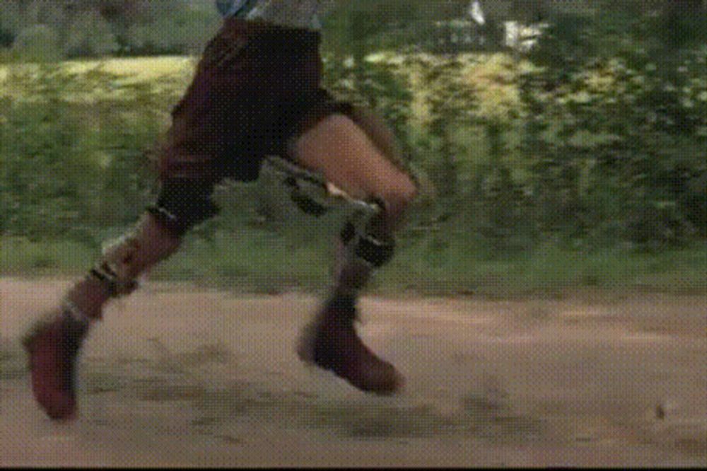 a person with a prosthetic leg is riding a skateboard on a dirt road