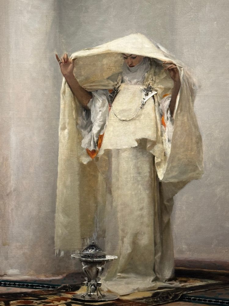 John Singer Sargent’s painting, Incensing the Veil. A woman dressed in white stands over an incense burner on the floor, holding draped white fabric over her head to corral the smoke. 