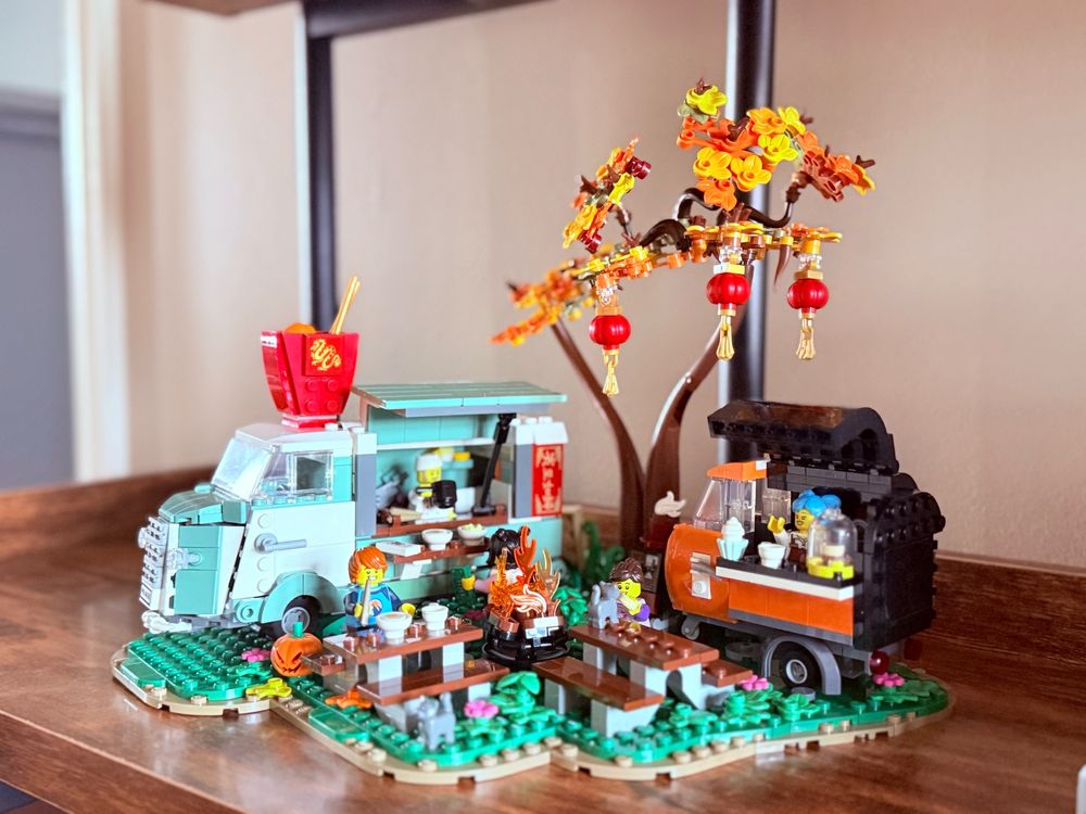 This is a MOC that incudes a vintage VW van noodle truck and a tuktuk coffee and bakery cart in a fall setting.