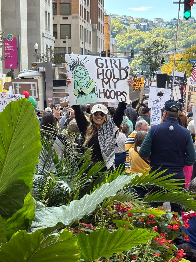 protester with sign of lady liberty removing earrings for a fight