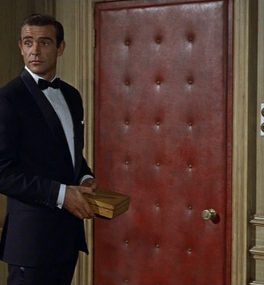 Sean Connery standing next to M’s memorable leather door (Dr. No, 1962) 