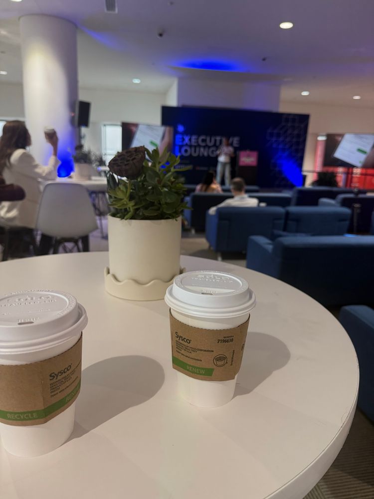 A cup of tea in a table at the back of a conference room 