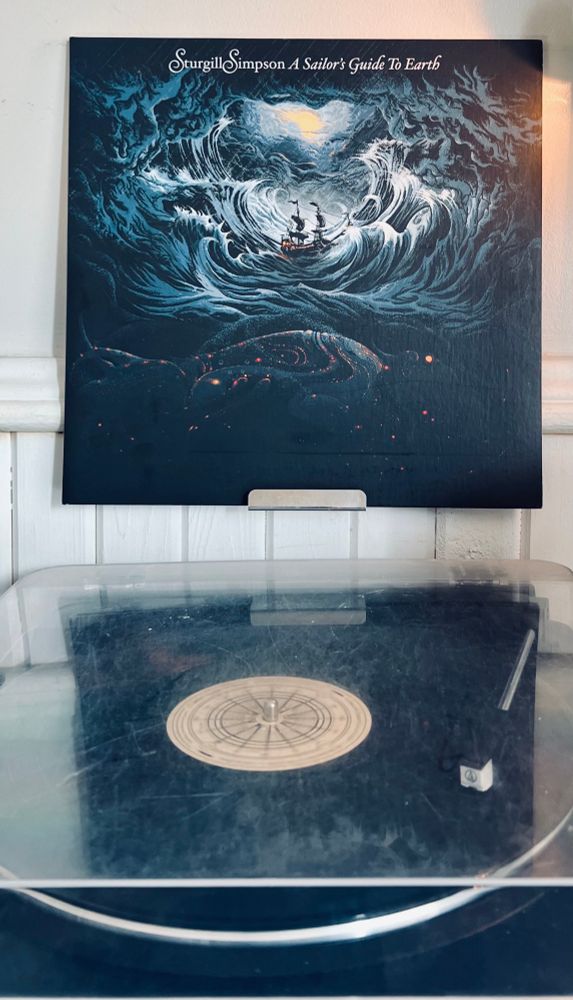 Turntable playing Sturgill Simpson’s 2016 album A Sailor’s Guide to Earth with the album cover displayed above. 