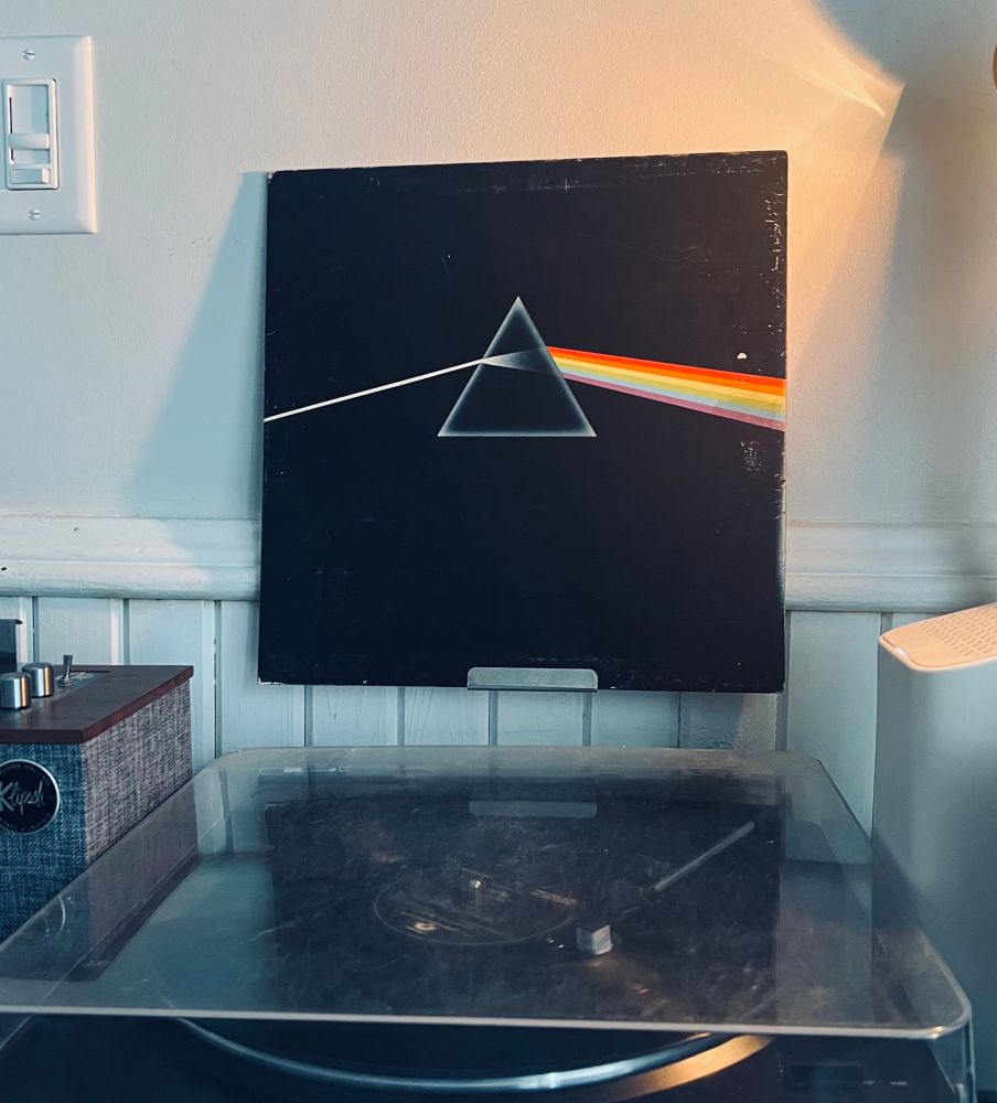 Turntable playing Pink Floyd’s album Dark Side of the Moon with the album cover displayed above. 