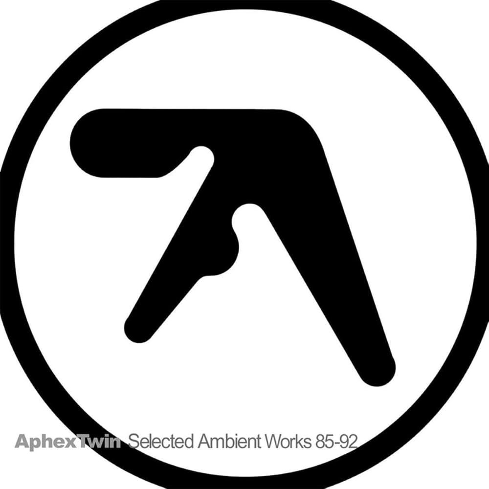 La pochette de l'album Selected Ambient Works 85-92 d'Aphex Twin sorti en 1992. Il représente le logo d'Aphex Twin, un 'A' stylisé en noir sur fond blanc entouré d'un cercle noir, et son titre en bas en petit.