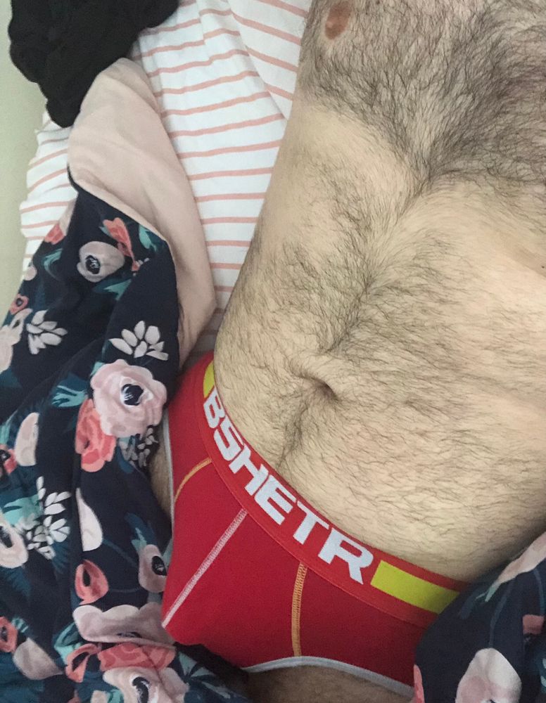 Me in my bed with my hairy body and red underwear bulge exposed