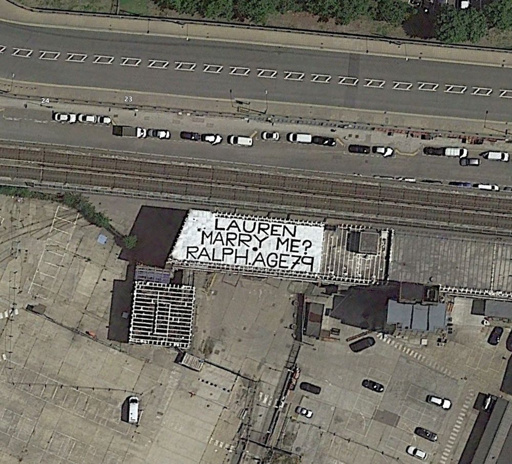 "LAUREN MARRY ME? RALPH AGE 79" written on the roof of a building in 2019 in West Silvertown, East London