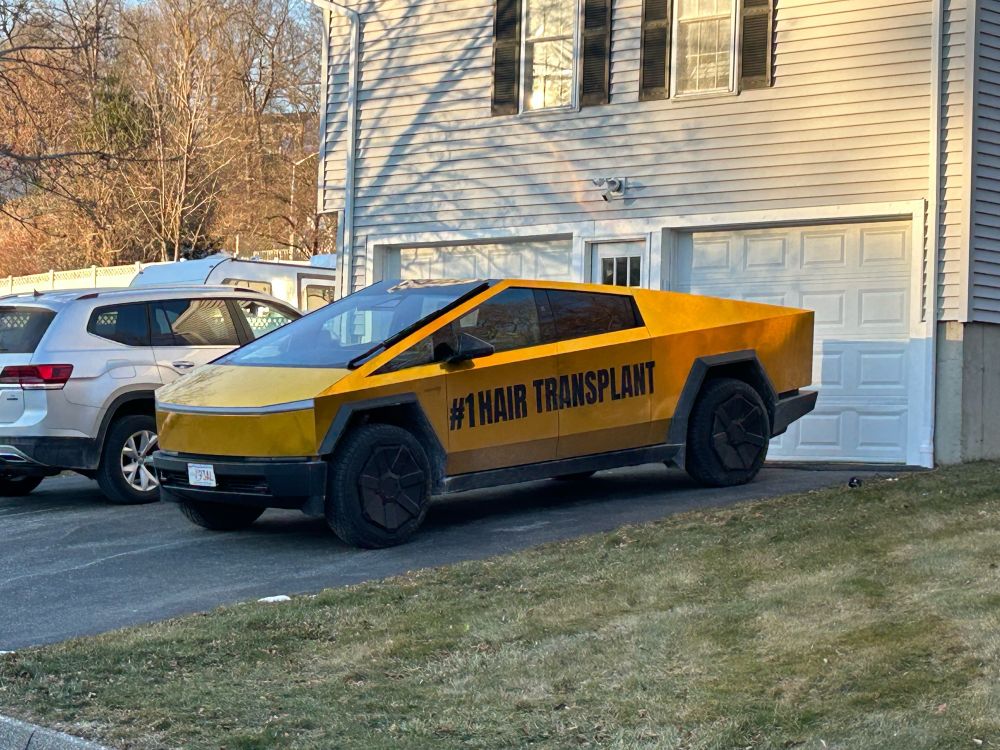 A gold cybertruck with the words “#1 HAIR TRANSPLANT” in all caps on the side 