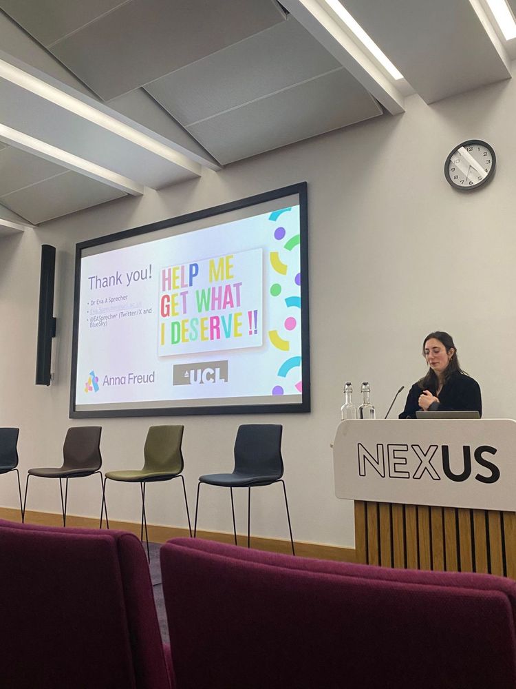 Eva stands at a podium in front of a screen that reads 'Thank you' and shows a postcard created by a young person that reads 'Help me get what I deserve'