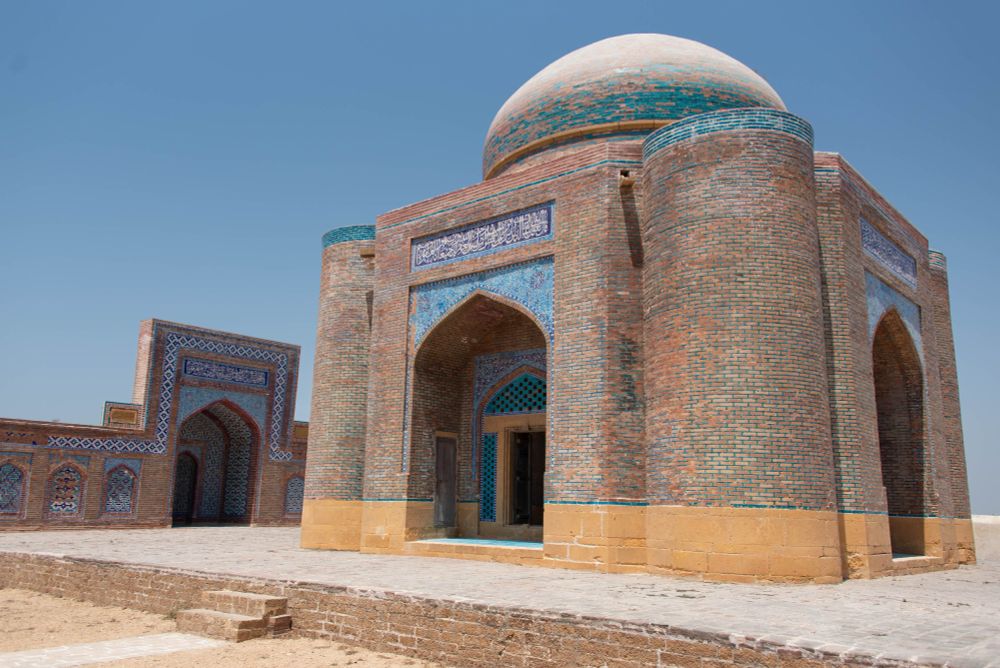Large, Mughal era mausoleum made of red brick with a blue tiled dome and blue tiled calligraphy over the 4 arched entrances. Built 1639.