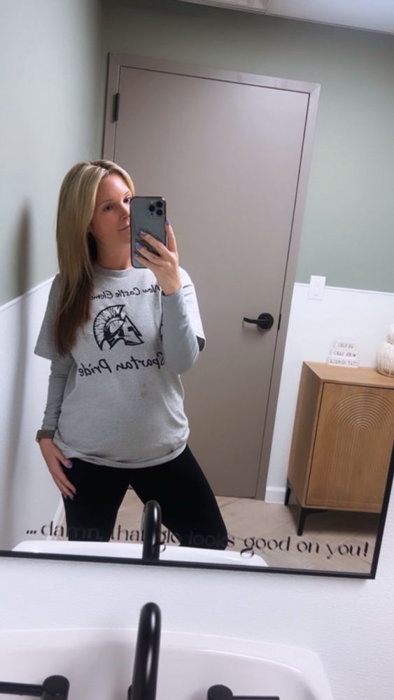 Mirror selfie, corny gray work tshirt coffee stain and all with black pants 