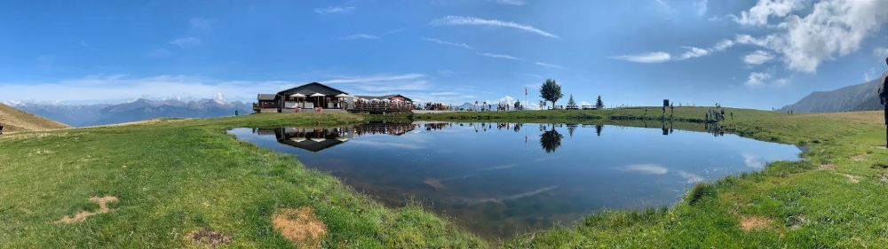 Foto of Alpe Foppa on Monte Tamaro, with the blue sky reflected in the alpine lake.