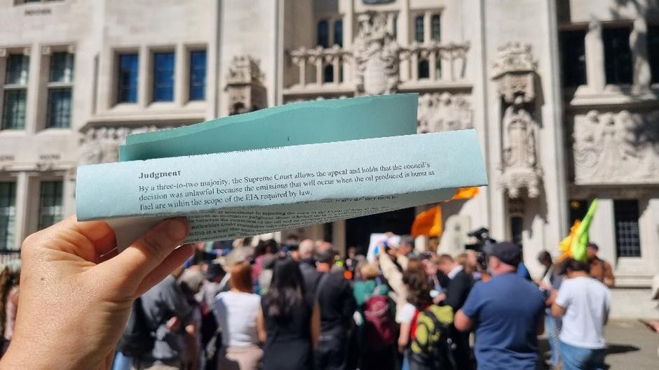 The Supreme Court's judgment held aloft in front of crowds at the Supreme Court.