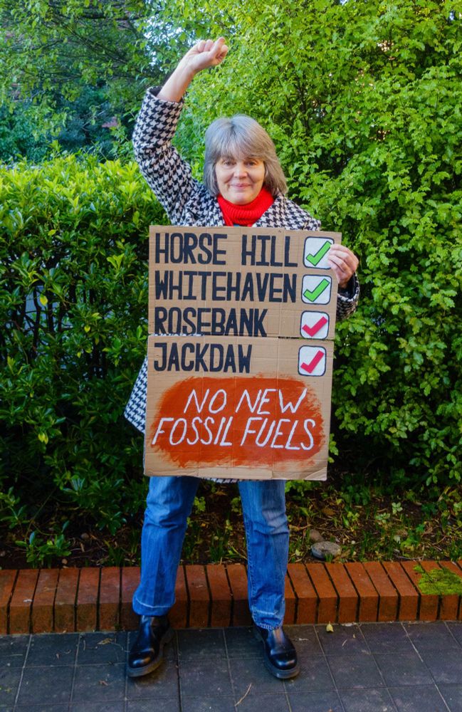 Campaigner Sarah Finch with placard celebrating the fact that the Rosebank & Jackdaw oil & gas fields have been found unlawful