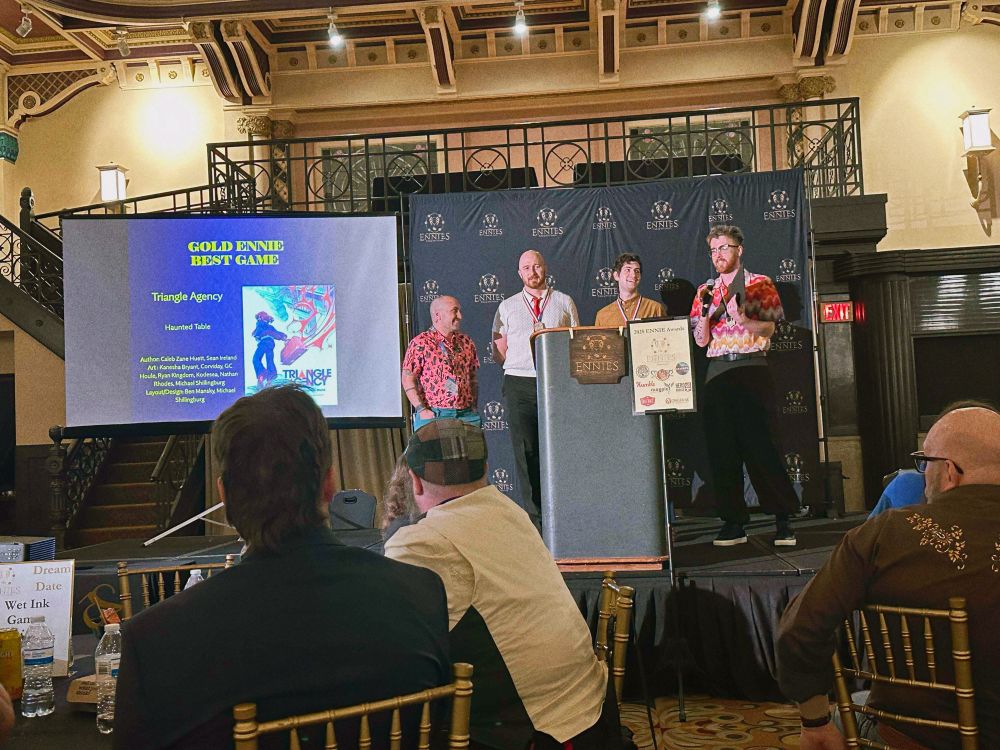 Ryan Kingdom, Sean Ireland, Ben Mansky, and Caleb Zane Huett on stage accepting the Gold Ennie for best game at the ennies.