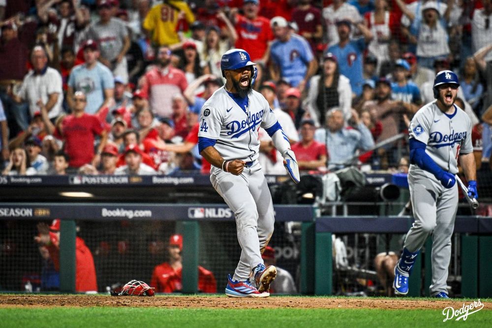 A photo of Teoscar Hernández scoring and yelling at home plate after being called safe.