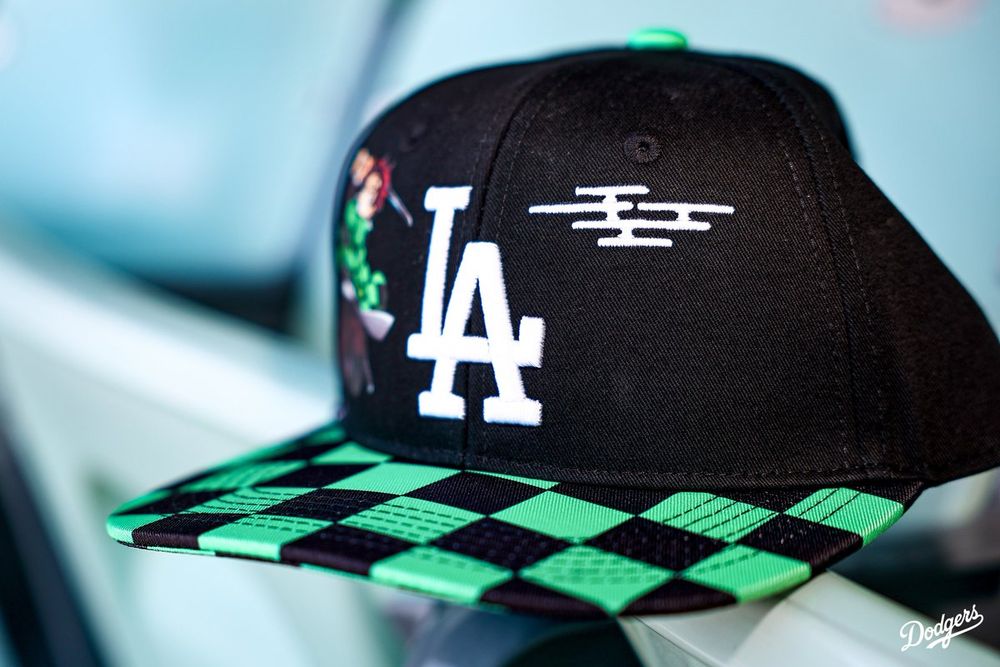 A closeup shot of the Dodgers x Demon Slayer hat placed on top of a seat at Dodger Stadium.