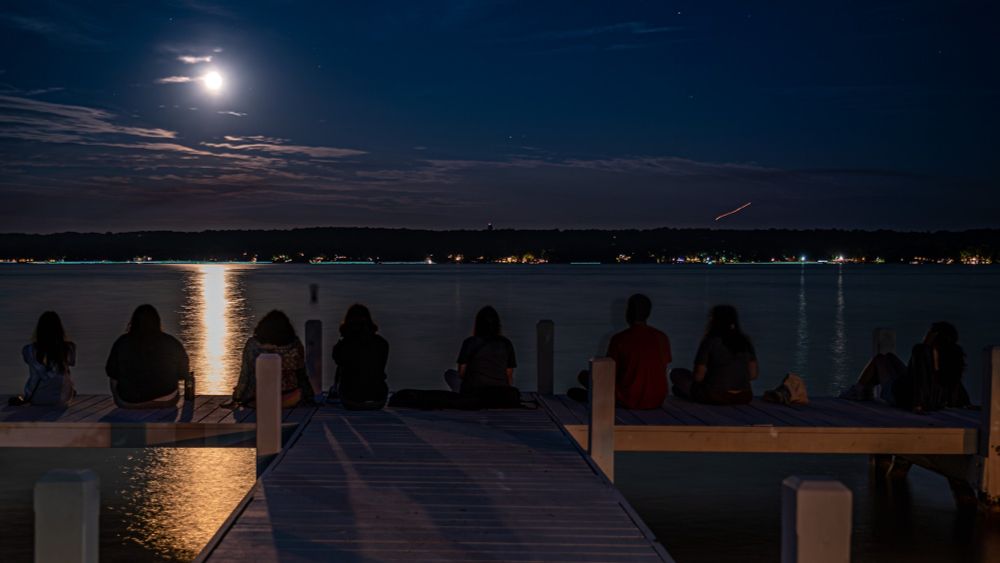 The 2023 Illinois IDEAS REU students watching the moon rise over Lake Geneva, WI.