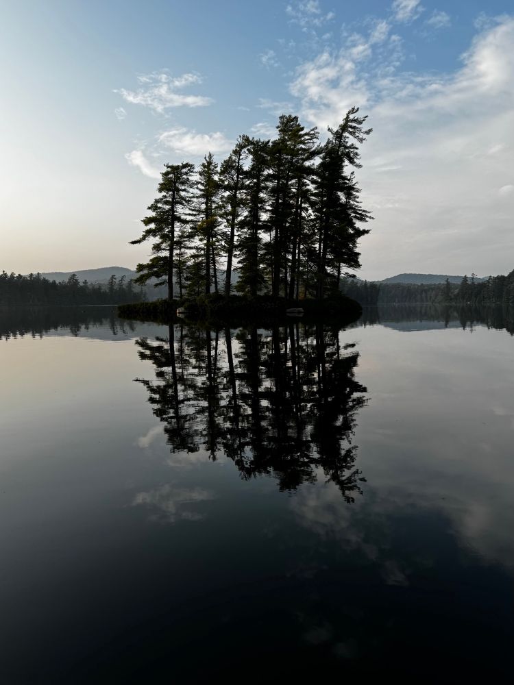 A small island in a lake in the Adirondacks, New York, with reflections in the lake