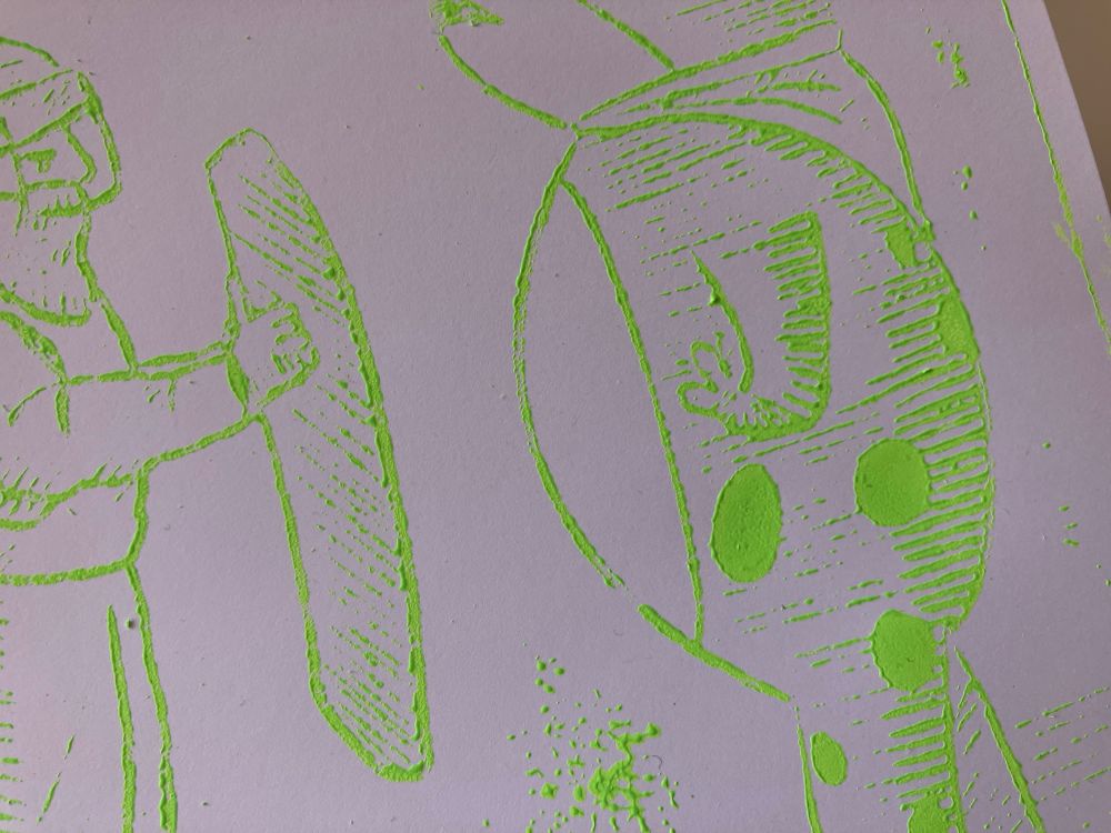 Closeup photo of a test print made with a laser engraved acrylic plate using @queermedieval.bsky.social's Portland Frog Hero art, showing the Speedball green fluorescent ink's tackiness sticking messily to the lines (print is also somewhat overinked)