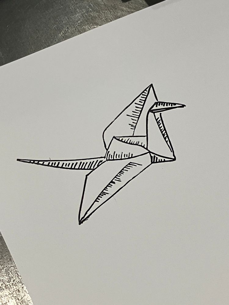 CloseuppPhoto of a white sheet of paper with an origami crane like a live drawing with parallel line shading, printed on it in black ink. It was printed using an acrylic lasercut block, ink, and a printing press.