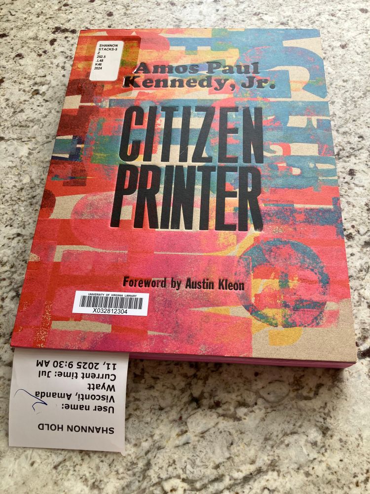 Photo of Amos Paul Kennedy Jr.'s book "Citizen Printer", a large book with colorful layered letterpress wood-type printing providing texture on the covers