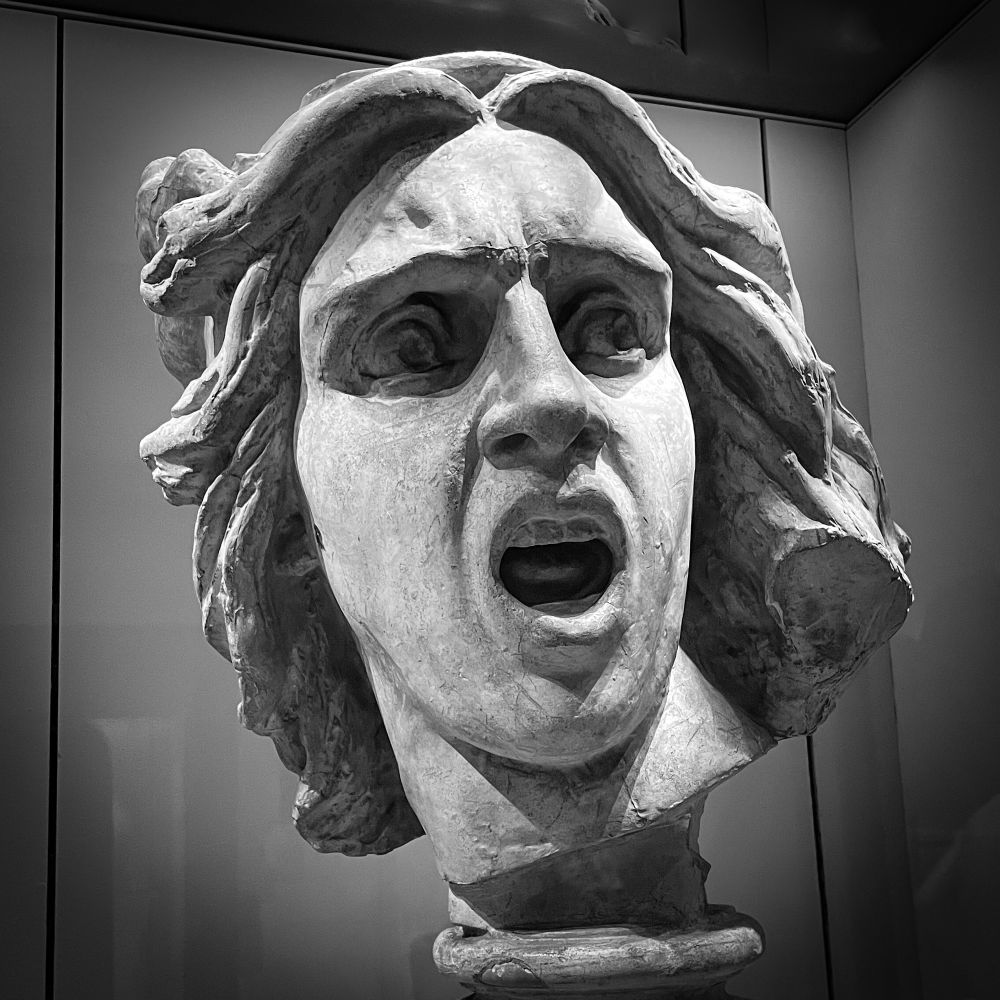 Détail de statue de l’arc de triomphe, genre le gars aux cheveux chelous qui crie très fort, en noir et blanc pour que ça fasse plus artistique