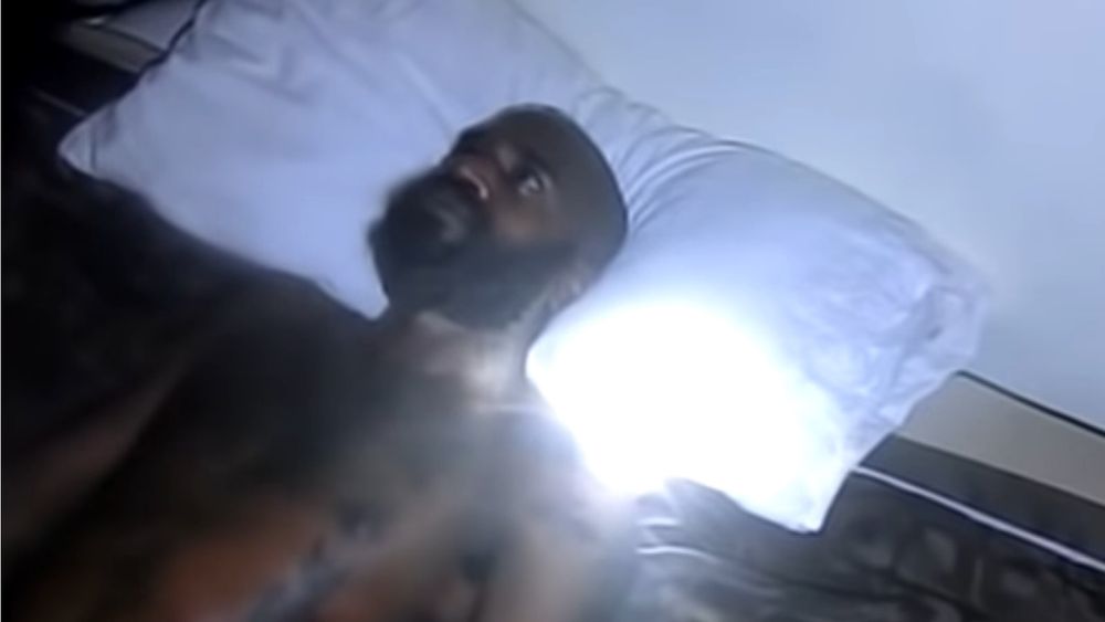 A man lying in bed wide awake and clearly not being able to sleep.
