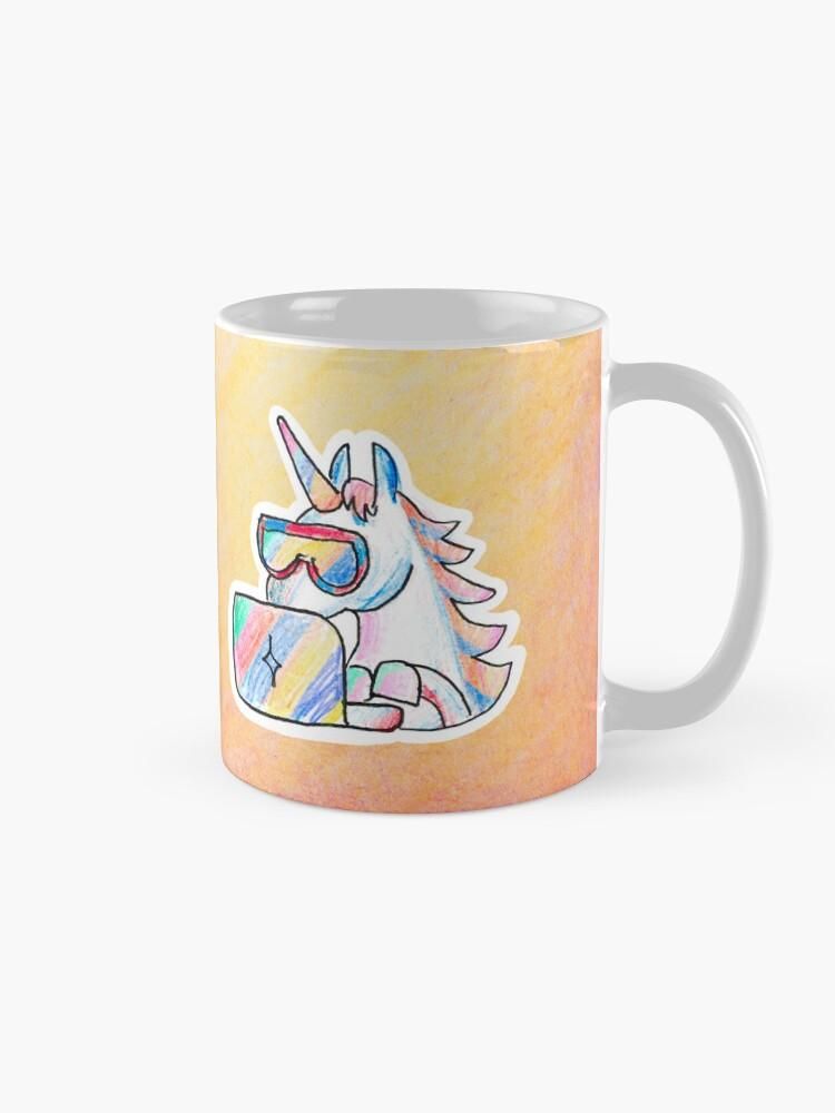 Product photo of a mug with a colorful hand-drawn unicorn wearing cool googles and typing into a notebook. The background of the artwork is yellow/orange.