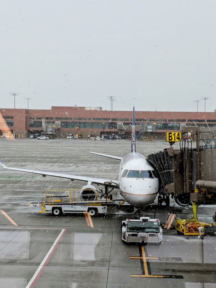 Plane at the Gate at the SLC airport while it's snowing a little bit