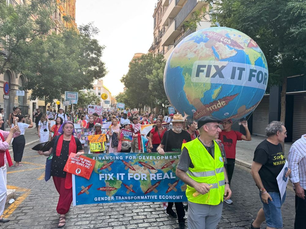 People in the street during the march with a big globe with the words: Fix it for real