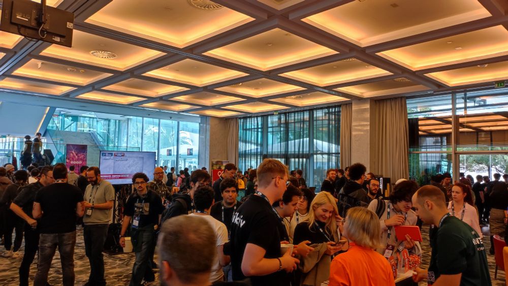 A photo of one of the halls with many people around at DevGAMM Lisbon 2025.