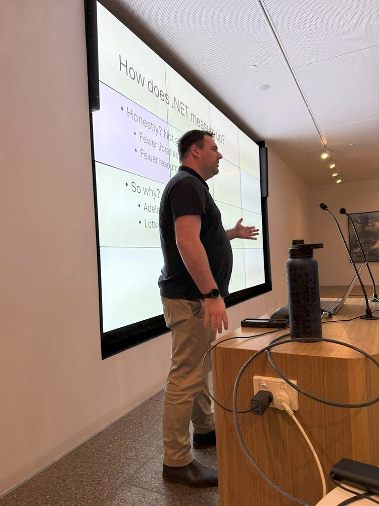David presenting in front of a large multi-monitor wall display