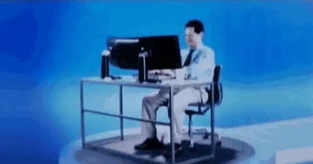 a man is sitting at a desk working on a computer .