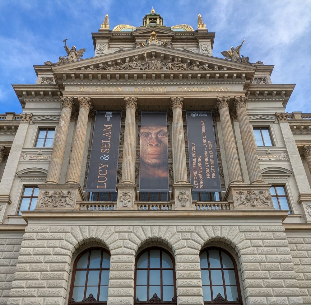 Photo of the front of Prague's National Museum with an Australopithecus banner