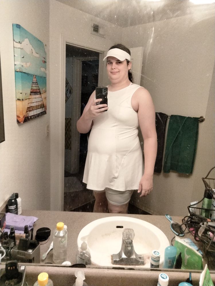 Me in a white tennis dress with matching shorts and visor.