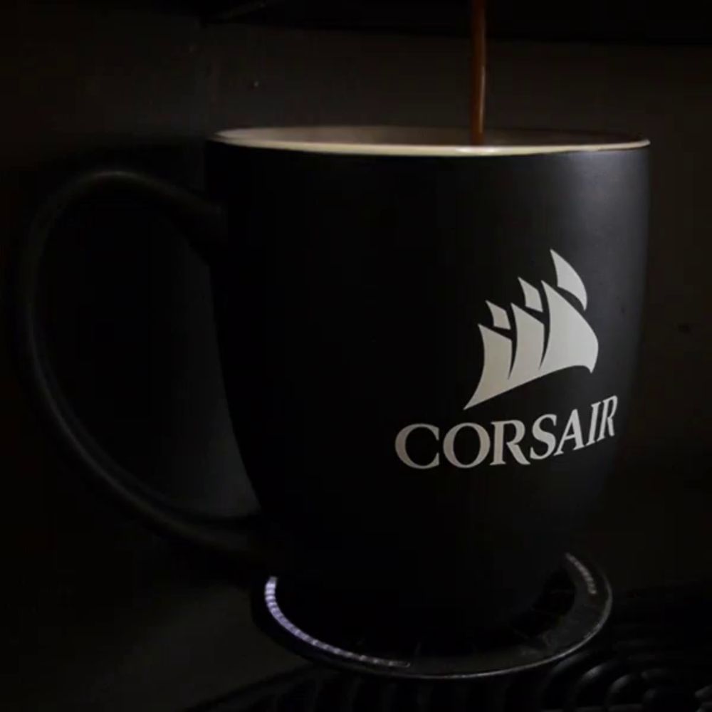 coffee is being poured into a black cup that says corsair