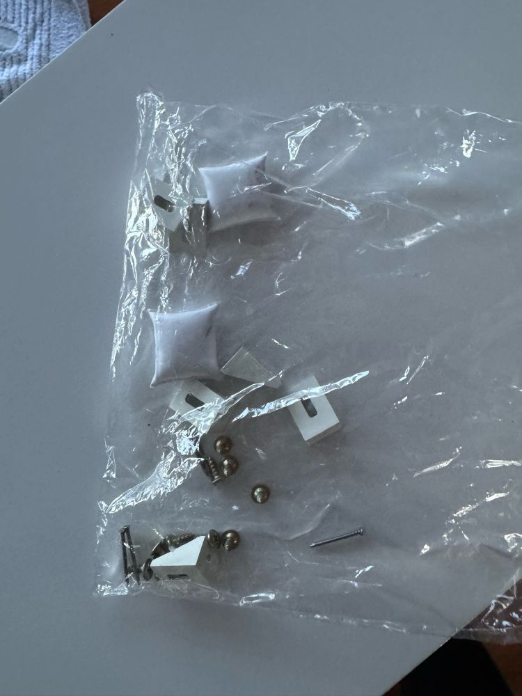 Um saco com peças que sobraram do gaveteiro (contém pregos, parafusos, cantoneiras e cola)