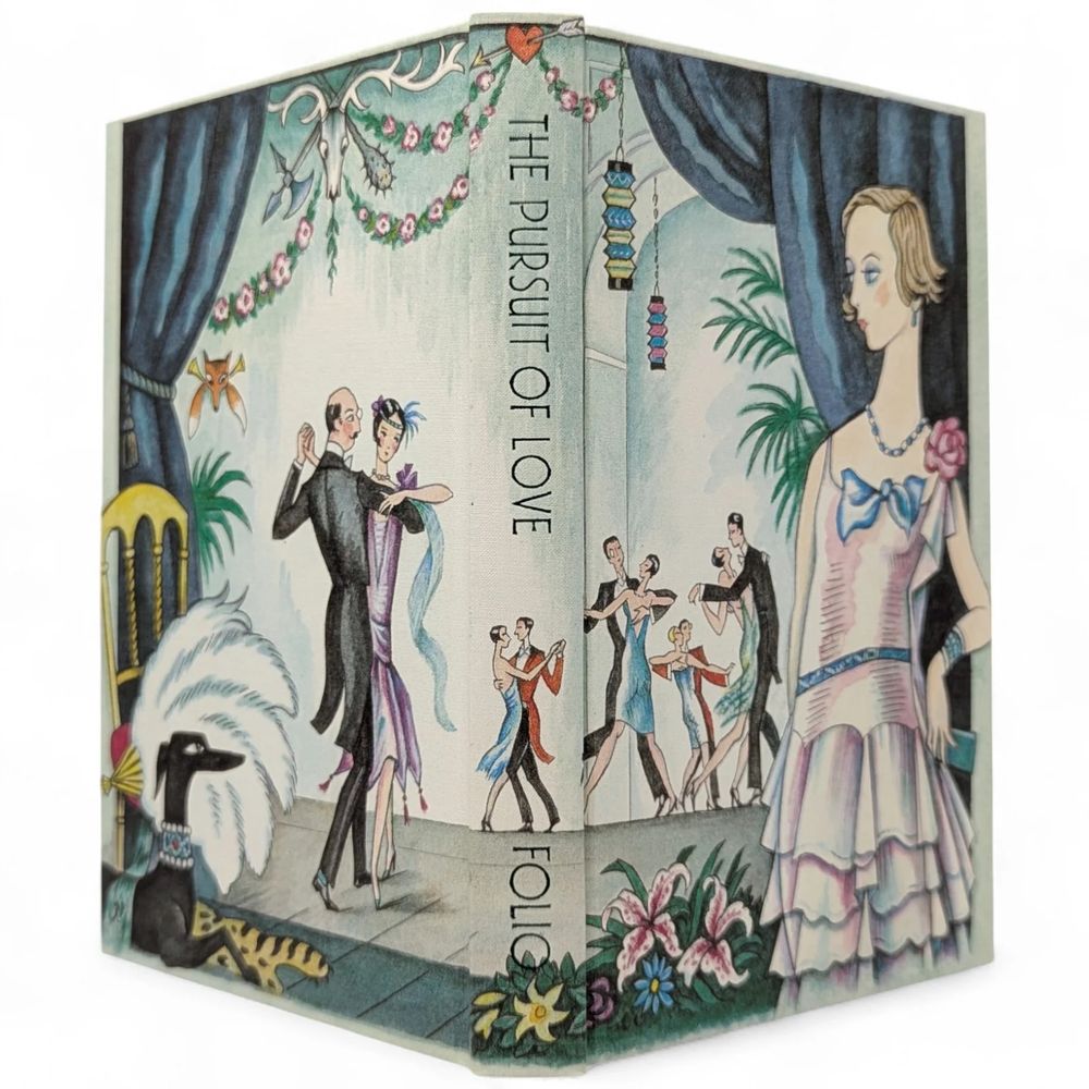 An illustrated book cover of "The Pursuit of Love" featuring elegant, vintage-styled characters dancing. The scene includes a couple in formal attire, a fashionable woman with a bob haircut, a black hunting dog wearing a decorative collar, and a variety of decorative elements like palms, flowers, colorful lanterns and hunting trophies.