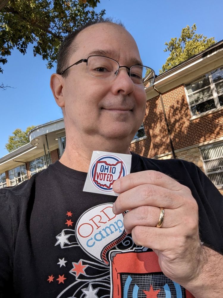 Me holding up an "I voted" sticker.