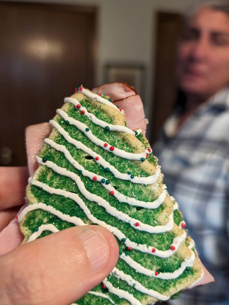 A Black Forest Ham and Strawberry Jam on Christmas Cookie sandwich, with long-suffering spouse in the background.