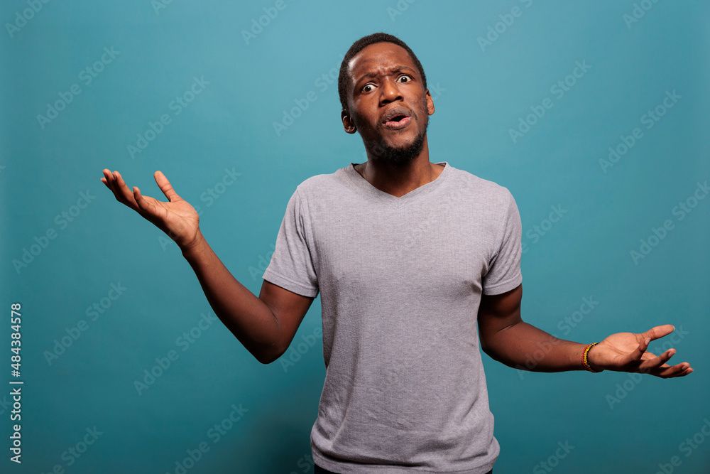 A confused, shrugging man with furrowed brow and mouth slightly ajar