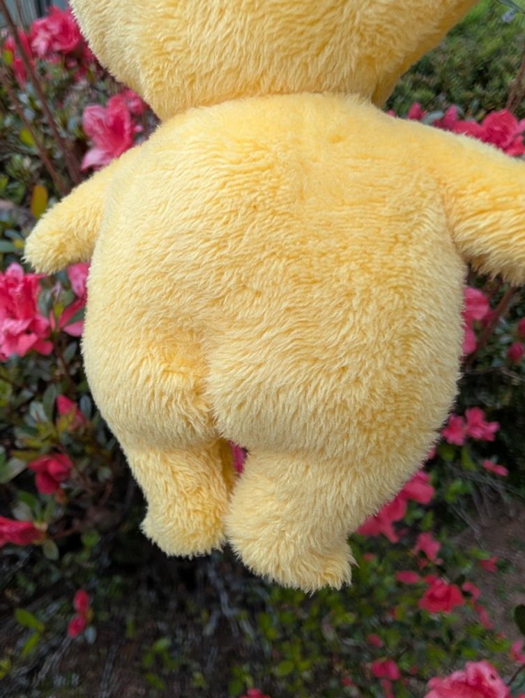 Close-up of a handmade yellow Pikmin plushie showing off its thread sculpted backside.