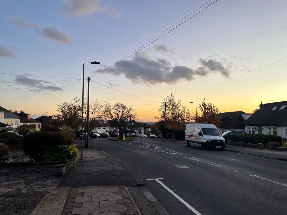 The view from a hill in the London suburbs (Mill Hill) looking south and west (the Wembley arch is visible). The sun is setting. The tree branches have no leaves. It’s not without beauty, but there is bleakness and sadness. 