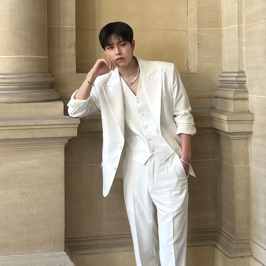 Picture of Seungmin from his visit to Paris shared from his Instagram.
He is wearing a white three-piece suit (no shirt 😳) and leaning with one elbow on a pillar.
