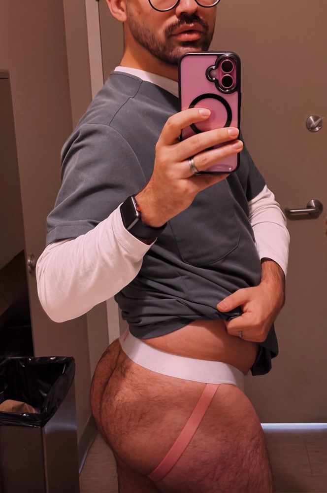 A mirror selfie of me with my pants pulled down to show off my fuzzy ass framed by a pink and white jockstrap