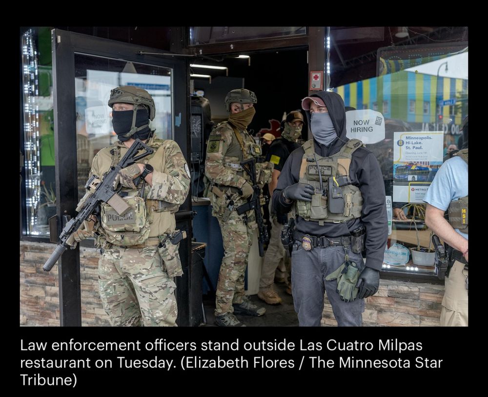 Federal law enforcement officials with millitary equipment standing outside local immigrant restaurant